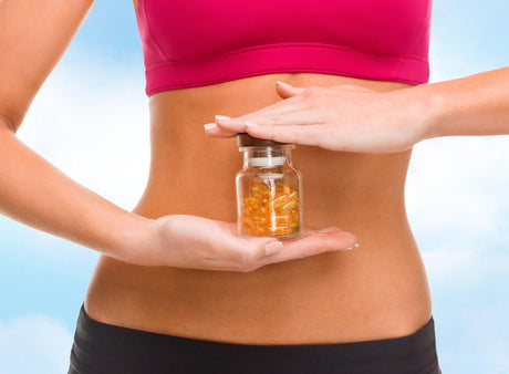Woman holding a small container of pills in front of her