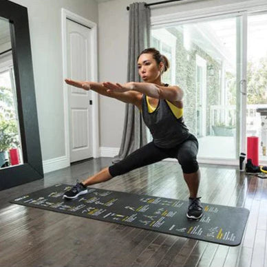 Woman practicing yoga on a mat in a home setting