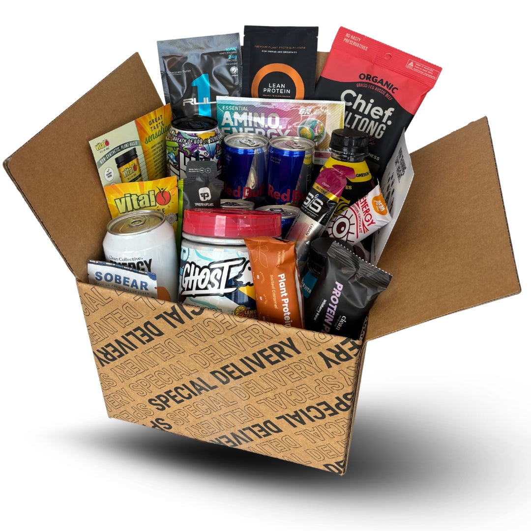 Box filled with various protein powder packages and supplements on a white background