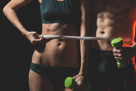 Athletic torso of a woman and a man getting measured