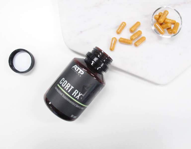 Open dark brown container and orange pills