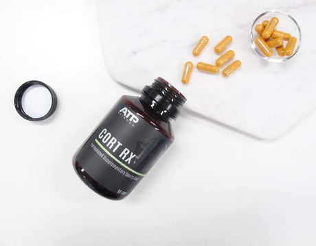 Open dark brown container and orange pills