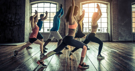 Handful of people performing stretches together.