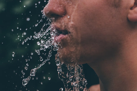 Water droplets splashing from a mans face