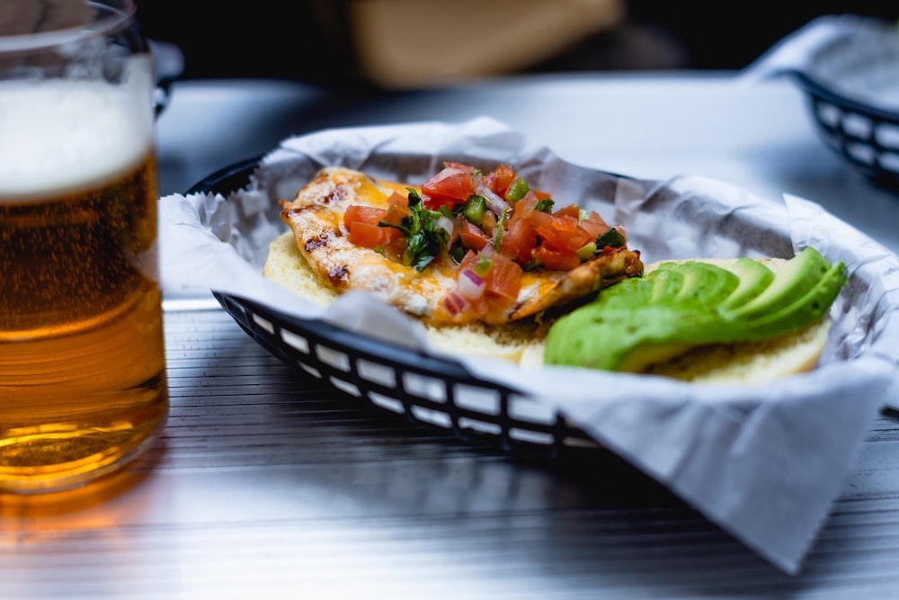 A chicken dinner sitting next to a glass of beer