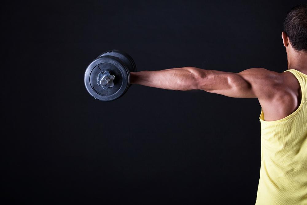 Man from behind holding up a dumbbell in a 90 degree angle