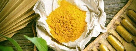 Yellow powder wrapped in paper and yellow capsules next to it