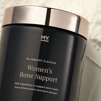 Black container labeled 'Women's Bone Support' with silver lid on a light background